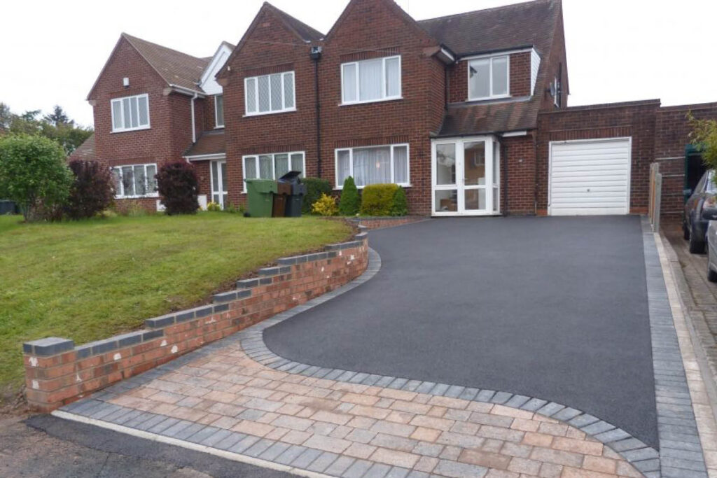 waved block paving edge to black tarmac driveway
